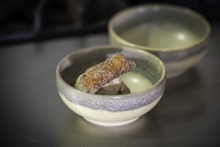 Ceramic bowl of ice cream topped with a pastry