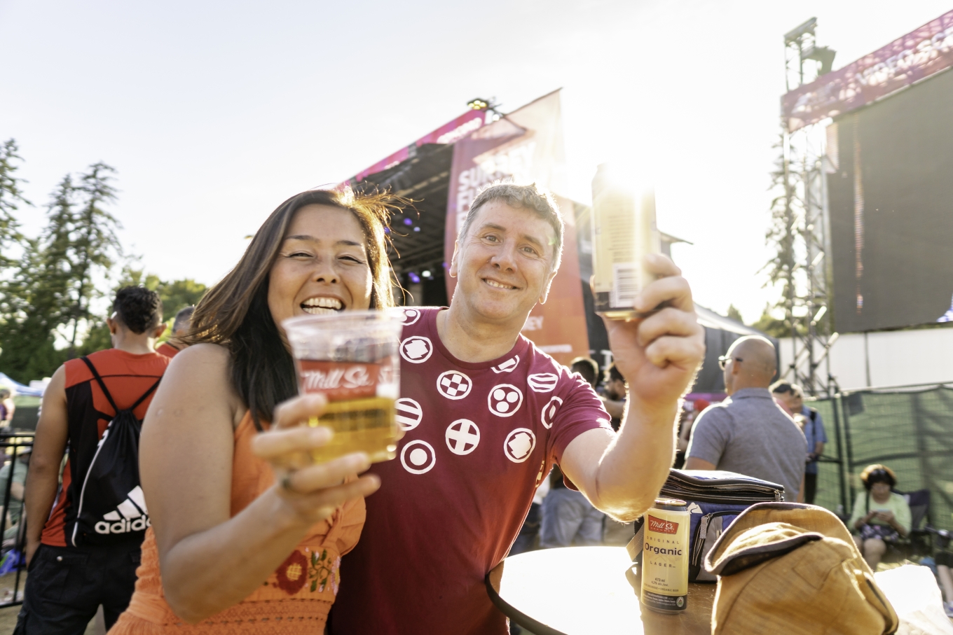 Smiling couple hold up two drinks in celebration