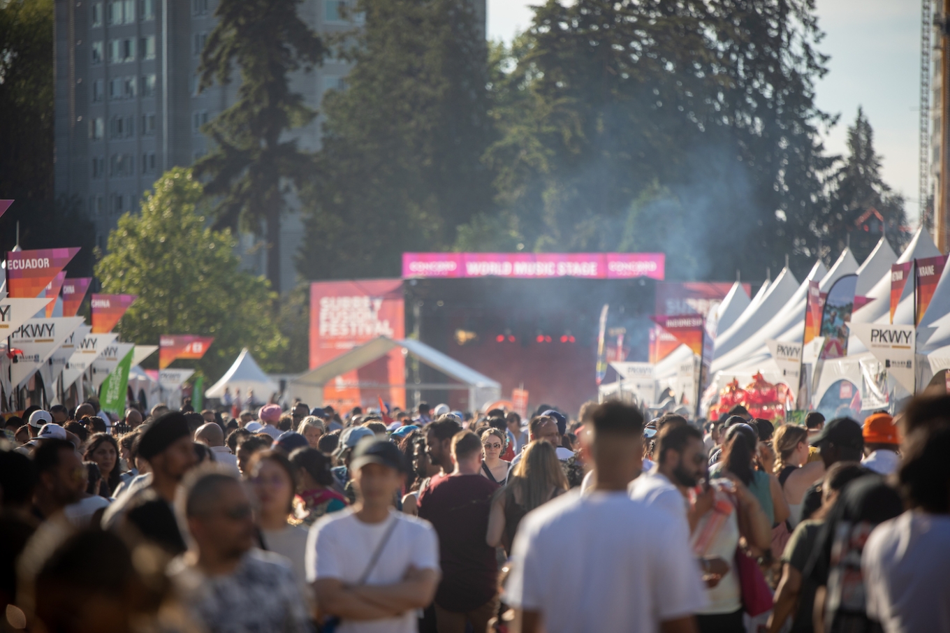Festival crowd explores rows of pavilions